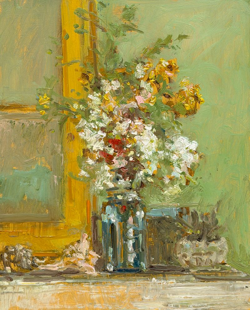 White and yellow flowers in a glass jar by a yellow frame