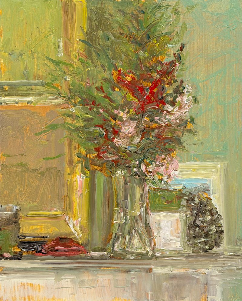 Red flowers in a glass vase by a window