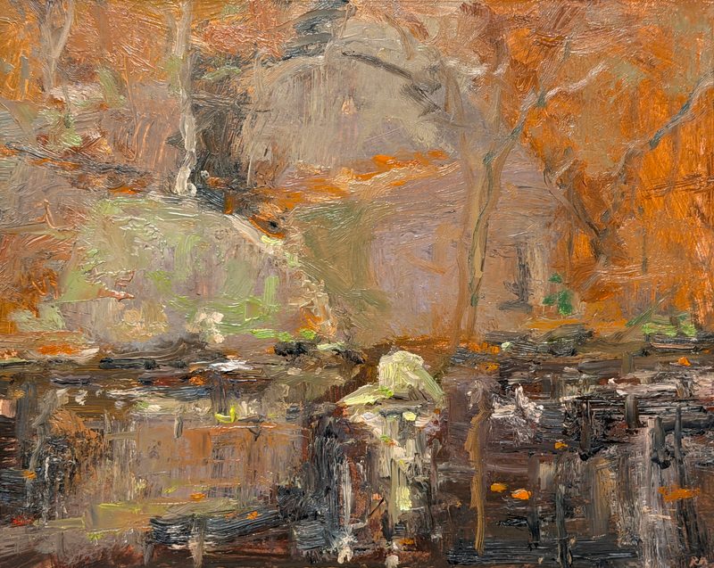 Orange autumn trees above rocks and dark water